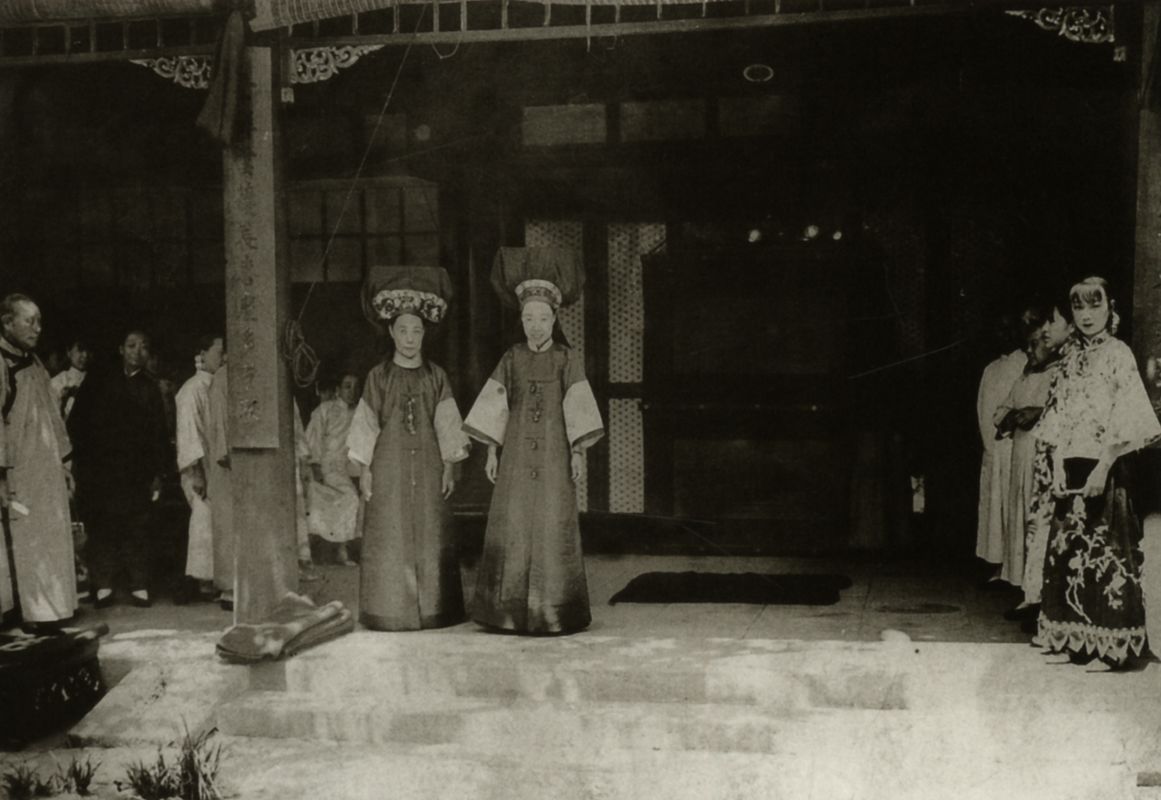 喜堂前的两位旗装妇女